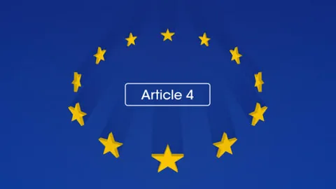 Équipe en réunion de travail consultant un document sur ordinateur portable, illustrant l'article 4 AI Act